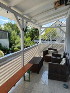 DiemardenにあるKornhaus Diemarden - 3-Zimmer, Pool, Whirlpool, Sauna, Kaminのポーチに木製のベンチと椅子が置かれたパティオ +14枚の写真