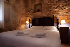 a bedroom with a bed with towels on it at Apartamentos Doña Candida in Valderrobres