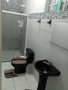 a bathroom with a black toilet and a shower at Carlos in Salvador