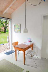 a dining room with a wooden table and two chairs at Kleines Gartenhaus in Havixbeck +5 photos