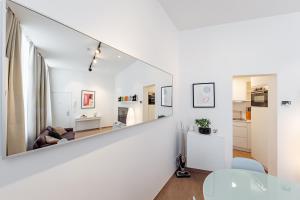 a white living room with a large mirror on the wall at Fully furnished and modern flat - Brussels center in Brussels +12 photos