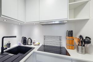 a kitchen with white cabinets and a black sink at Fully furnished and modern flat - Brussels center in Brussels