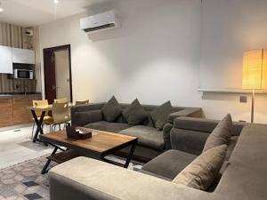 a living room with a couch and a table at شركة منازل التوت للشقق المخدومة جده in Jeddah