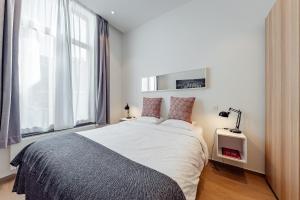 a bedroom with a large bed and a window at Fully furnished and modern flat - Brussels center in Brussels