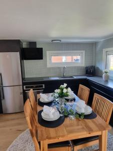 a wooden table with plates and flowers on it in a kitchen at Villa Lakeside in Osbyholm