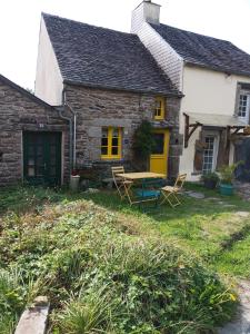 a house with a yellow door and a table at "La Maison de Poupée" Gîte cosy Monts d'Arrée proche Huelgoat Bretagne in Berrien