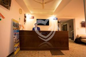 a man at a reception desk in a room at Resort de alcazar in Calangute