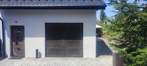 a small white building with a large door at Apartament KAOLA in Jelenia Góra