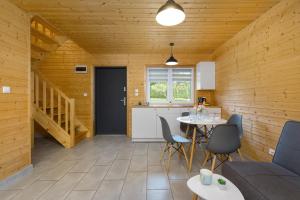 a kitchen and a living room with a table and chairs at Topolowa by Solarento in Mielenko