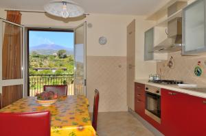 a kitchen with a table with a bowl of fruit on it at Tra il fuoco dell'Etna e Taormina in Piedimonte Etneo