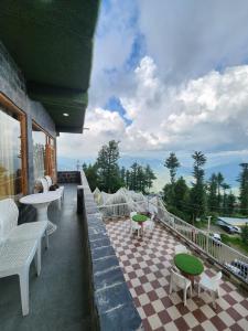 a balcony with a checkered floor and tables and chairs at Sneh by Daisey in Cheog