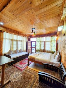 a bedroom with two beds and a wooden ceiling at Sneh by Daisey in Cheog