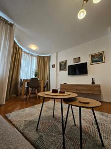 un soggiorno con un tavolo e una TV di Apartmani Dragulji Krusevac a Kruševac