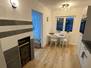 a living room with a fireplace and a table with chairs at Ferienwohnung Linner in Gmunden