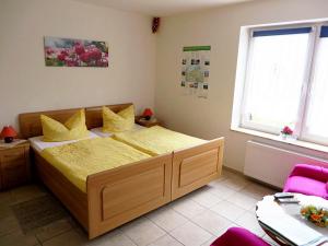 a bedroom with a bed with yellow sheets and yellow pillows at Ferienwohnungen "Marie" mit Terrassen, inclusive Park- und Stellplätze am Haus, Müritz-Strand nur 700m, Altstadt 10min, ruhige Lage, in Waren