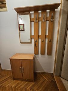 a dressing room with wooden cabinets and a mirror at Apartments Dragulji Kruševac Central Stay in Kruševac