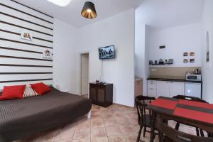 a bedroom with a bed and a table and a kitchen at Ecoappartment in Mosonmagyaróvár