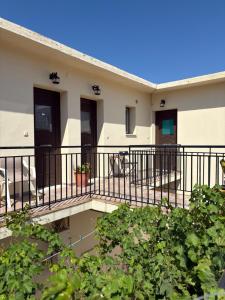 a building with a balcony with plants at Vista del Mare Rooms 1 in Agios Ioannis Kaspaka