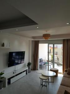 a living room with a couch and a tv and a table at South Coast Apartments AL2 in Sarandë