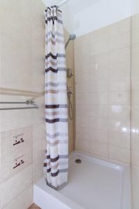 a shower with a black and white shower curtain in a bathroom at Ecoappartment in Mosonmagyaróvár