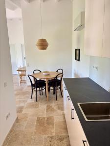 a kitchen with a table and chairs in a room at Vale do Guizo: Casa Poente on the contryside, close by the sea. in Aljezur