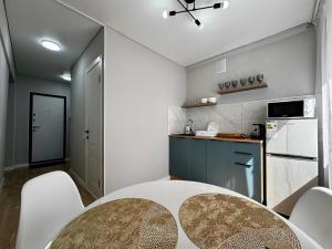 Una cocina con una mesa y sillas en una habitación. en Квартира - Кэнди, en Öskemen 11 fotos más