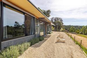 un bâtiment avec des fenêtres à côté d'un chemin de terre dans l'établissement Refugio Cunha - Vista Panorâmica, à Cunha