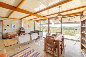 un salon avec une table et des chaises et une cheminée dans l'établissement Refugio Cunha - Vista Panorâmica, à Cunha
