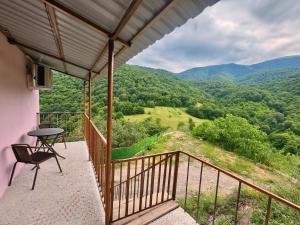 a balcony with a table and a chair and a view at Goshniver Rest House in Dilijan