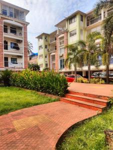 a brick walkway in front of some apartment buildings at Studio flats in Candolim in Candolim