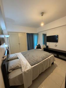 a bedroom with a large bed and a flat screen tv at Quarto de casal in Costa da Caparica