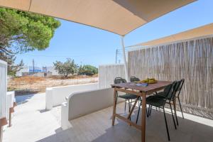 a wooden table and chairs on a balcony at All Welcome in Pollonia