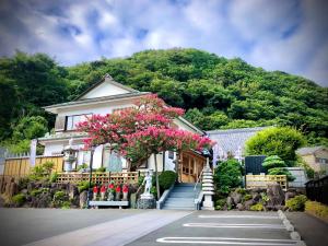 a house with pink flowers in front of it at 宿坊長運寺 in Hayama