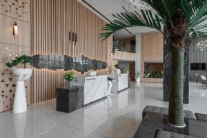 a lobby with a palm tree in a building at Rhenium Hotel Abha in Abha