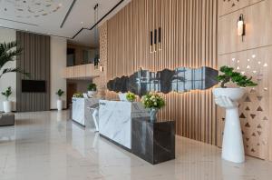 a lobby with a row of tables with potted plants at Rhenium Hotel Abha in Abha +48 photos
