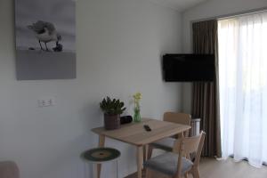 a living room with a table and a bird on the wall at De Strandloper Zeeland, Studio nabij strand 3km in Koudekerke