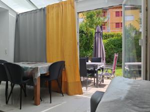 a patio with a table and chairs and an umbrella at Garten Apartment in Müllheim