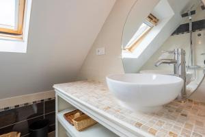 une salle de bain avec un lavabo et un miroir dans l'établissement Maison de vacances proche de tout, à Quimper