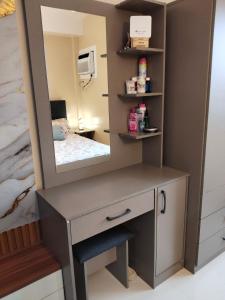 Un tocador con espejo en un dormitorio. en Rhiangelo Condo Suite in Cebu City, en Cebú