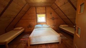 a bedroom in a log cabin with a bed and a window at U Świstaka in Krasnobród