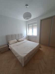 a bedroom with a large bed in a white room at Angela Modern Apartment in Bitola +8 photos