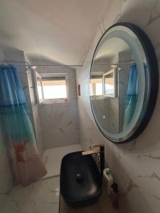 La salle de bains est pourvue d'un miroir rond et d'un lavabo. dans l'établissement Apartman Denis, à Vir 17 autres photos