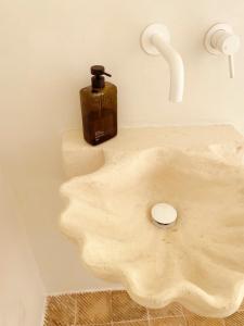 a soap dispenser sitting on top of a bathroom sink at Ferienhaus, Villa in der Altstadt mit grossem Zitrusgarten in Carovigno