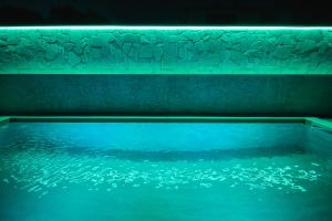 a bath tub filled with blue water in a room at Villa Aura - Pag Island in Jakišnica