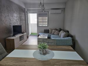 a living room with a bed and a tv at Zen Central Gevgelija in Gevgelija