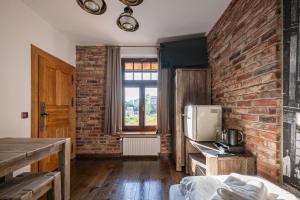a room with a brick wall and a kitchen at Stara Przepompownia in Ostrów Wielkopolski