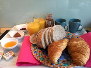里爾的住宿－盧米埃住宿加早餐旅館，桌上放着一盘面包和羊角面包