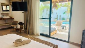 a bedroom with a bed and a view of a pool at Villa Chanalu in Ngaparou +92 photos