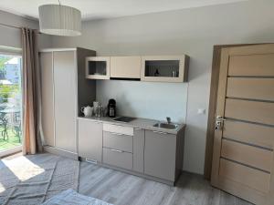 a small kitchen with a sink and a door at Platinium in Karwia +7 photos