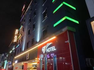 木浦市Mokpo Well hotel的楼边有 ⁇ 虹灯标志的酒店